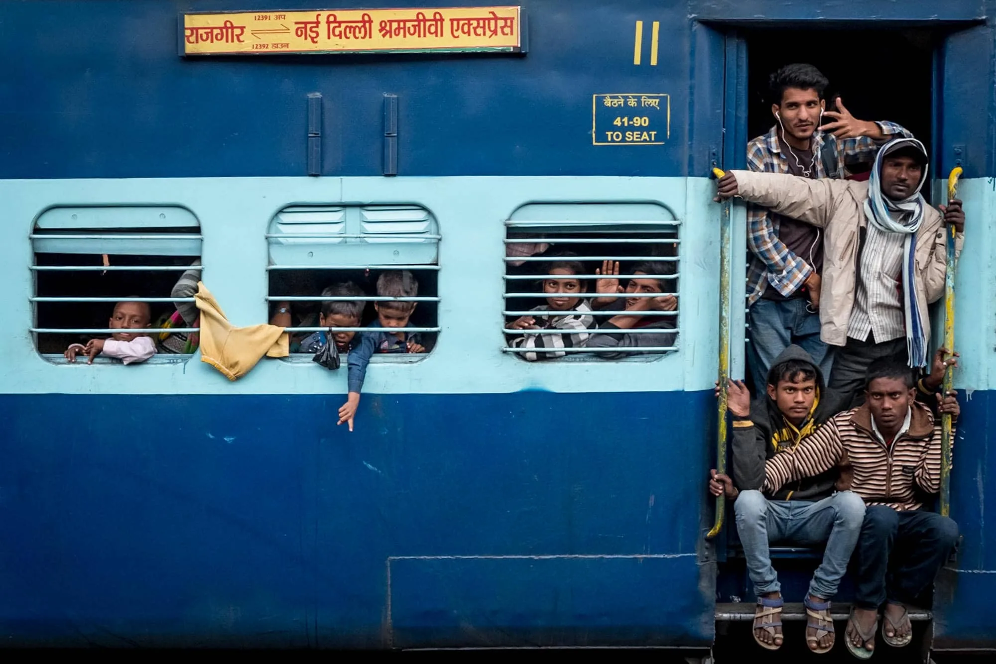 A blue train packed with people taken during india street photography trip