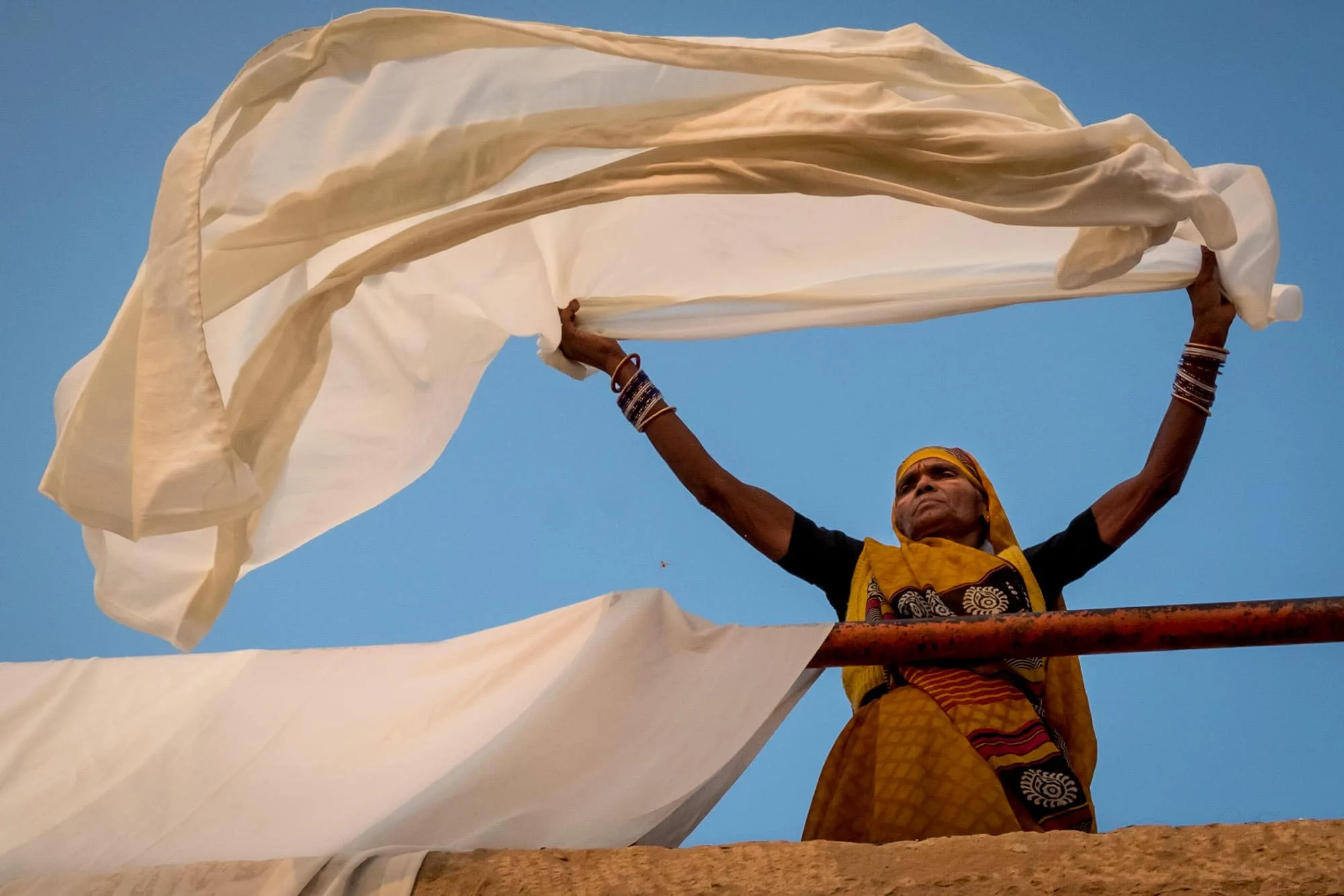 An Indian women trying sheets at sunrise in Varanasi